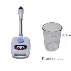 White electronic device with a handle and digital display next to a clear plastic cup on a white background.