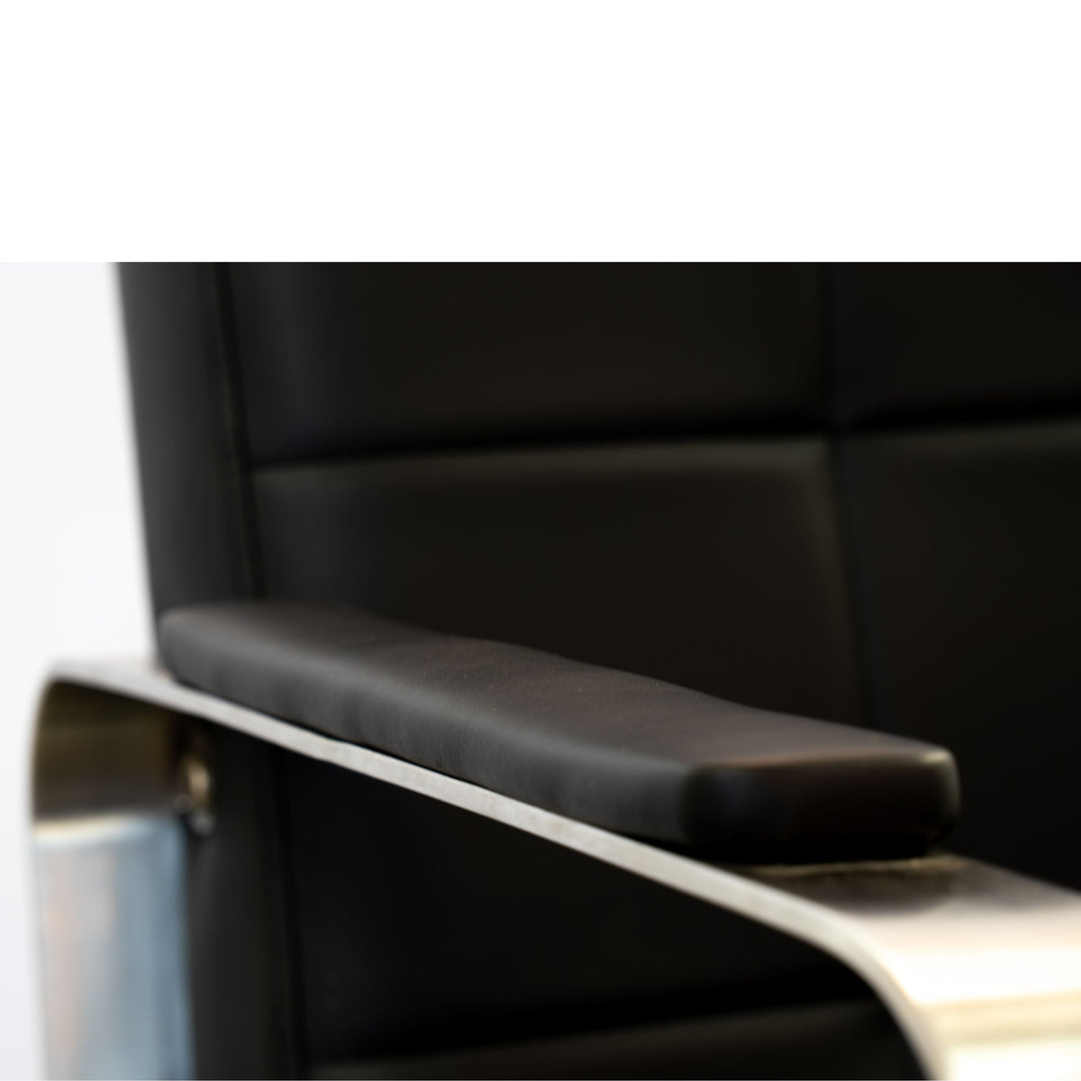 Close-up of the Karma Lithgow salon chair showing the black tufted backrest